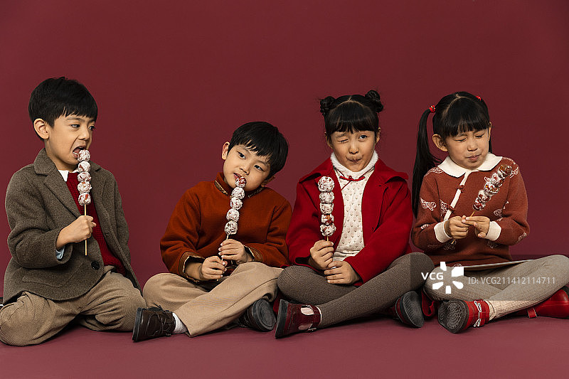 儿童庆祝春节系列：欢乐的儿童们吃糖葫芦庆祝新春图片素材