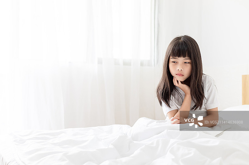 床上一个生病感冒的中国小女孩图片素材