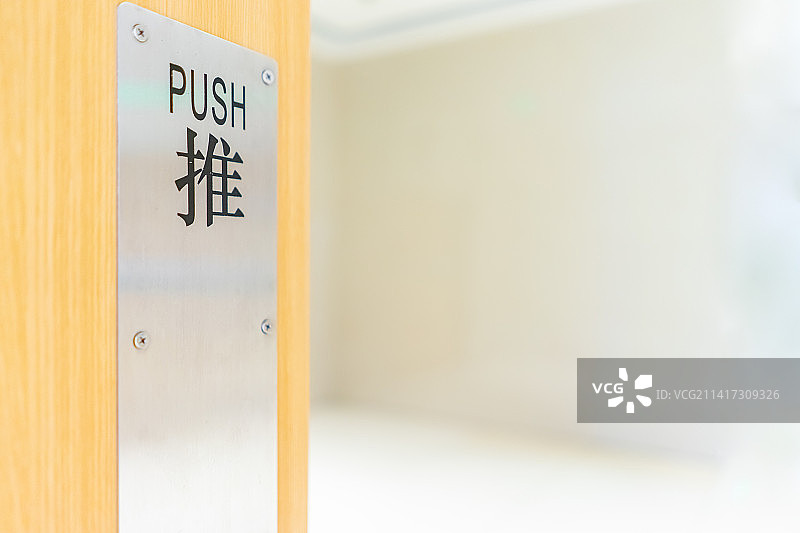 中国公共建筑公共设施拍摄主题，黄色的木制大门上的不锈钢的方形标志特写，室内无人图像摄影图片素材