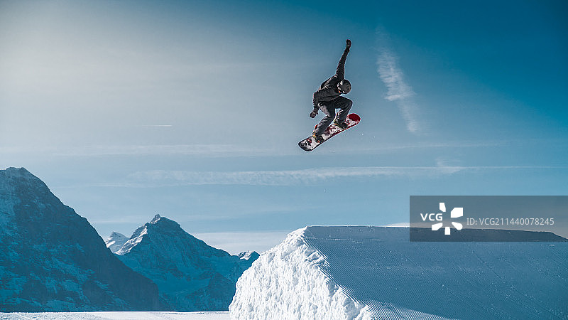 雪山上跳跃起的滑雪者图片素材