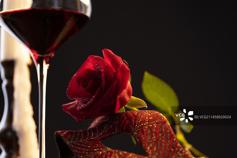 红酒、化妆面具、红玫瑰和烛台静物特写图片素材
