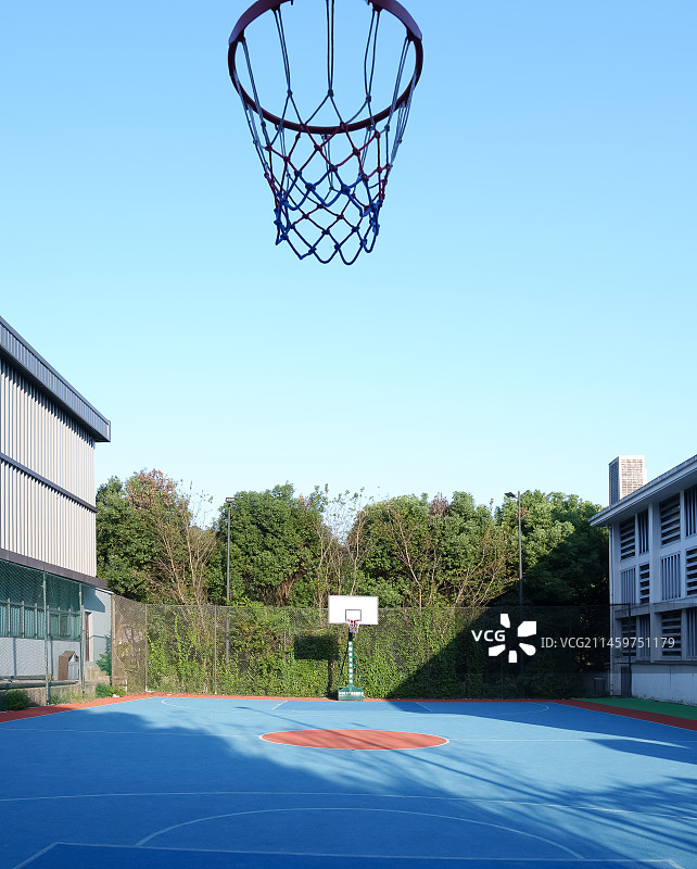 空旷的篮球场和蓝天下的建筑物图片素材