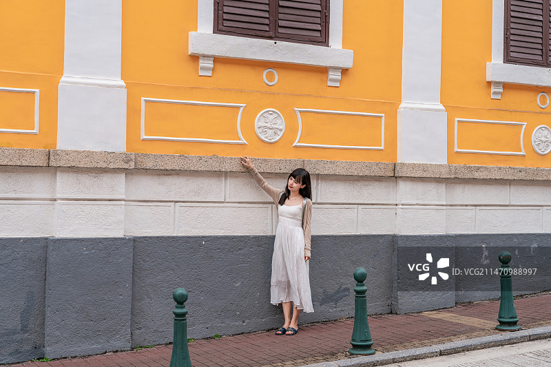 欧洲街头黄色建筑街道穿着白色裙子的女生图片素材