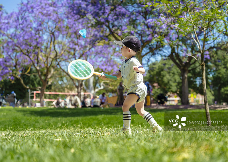 公园草坪上打羽毛球小男孩图片素材
