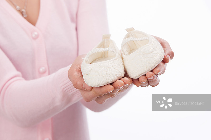 女人的手拿着婴儿鞋图片素材