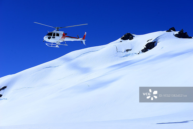 雪山顶飞行的直升飞机图片素材