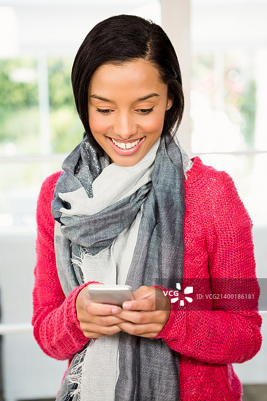 微笑的黑发女子使用智能手机图片素材