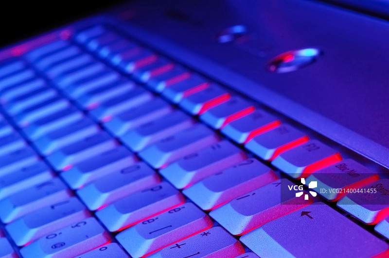 一个打开笔记本的键盘的特写照片;蓝色红色基调图片素材
