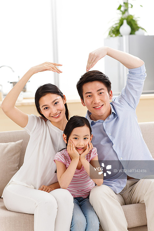 幸福的一家三口坐在客厅的沙发上图片素材
