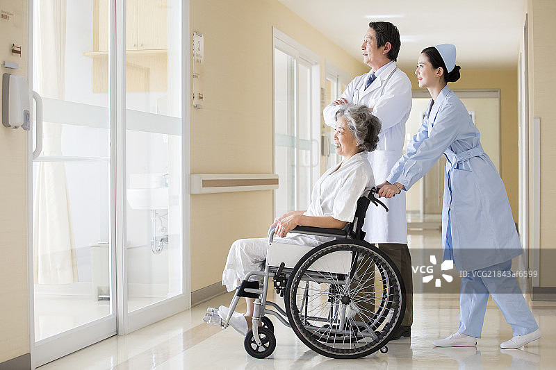 医护人员照顾坐轮椅的老人图片素材