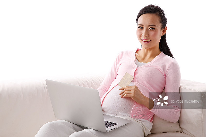 孕妇坐在沙发上网上购物图片素材