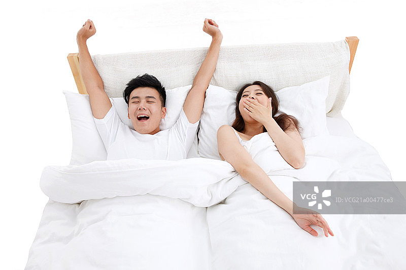 青年夫妇仰卧在床上打哈欠图片素材