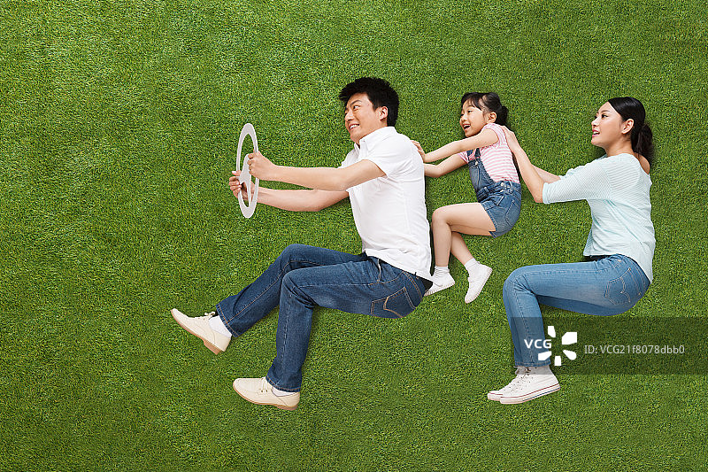 欢乐的一家三口在草地上驾驶图片素材