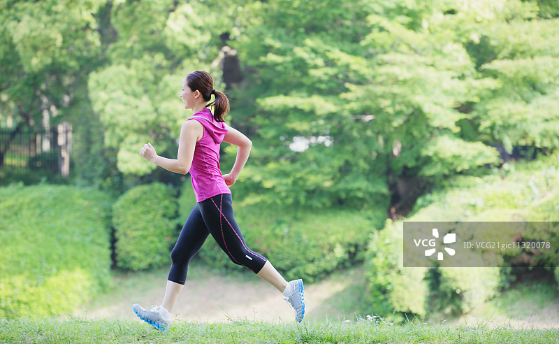 年轻的日本女孩在公园里跑步图片素材