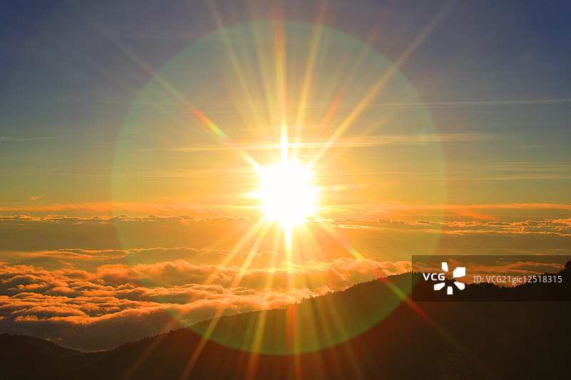 清晨的太阳笼罩在山那边的低云之上图片素材