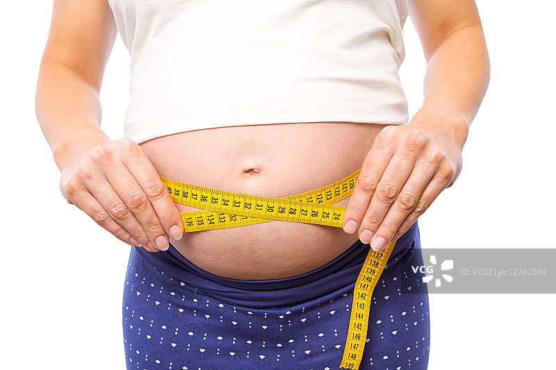 一名孕妇在白色背景下测量自己的肚子图片素材
