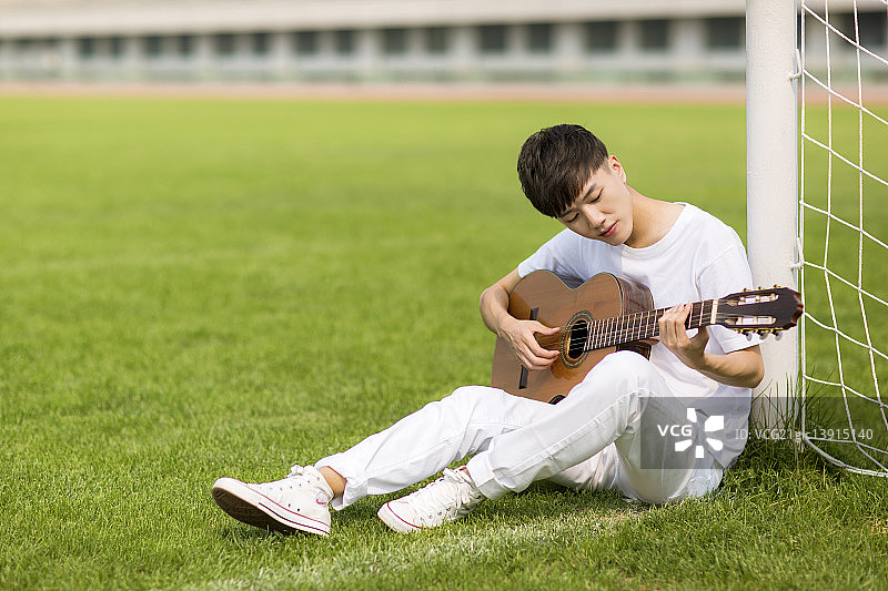 坐着弹吉他的男学生图片素材