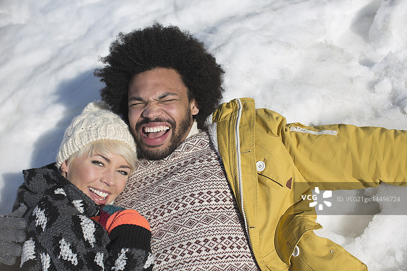 一对幸福的夫妇躺在雪地里图片素材