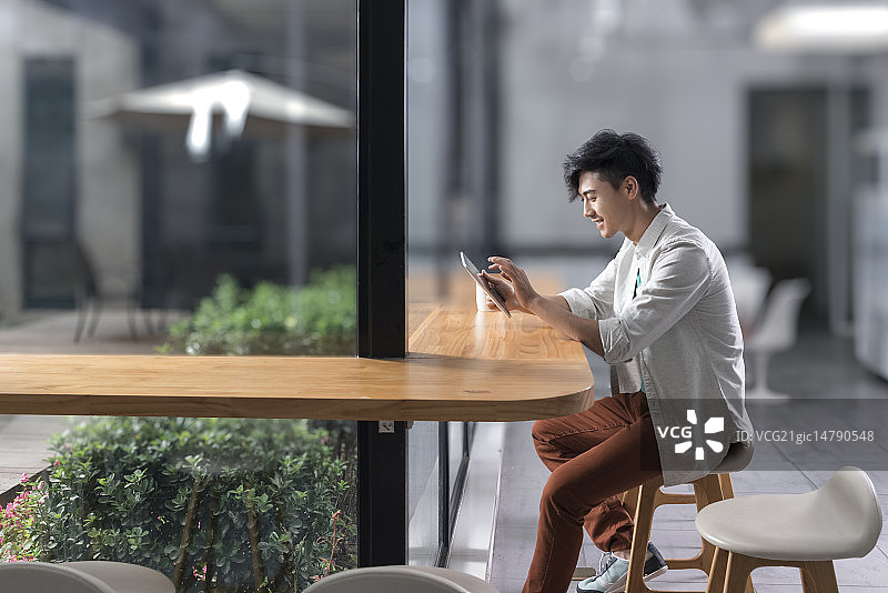 Creative businessman using digital tablet in break room图片素材