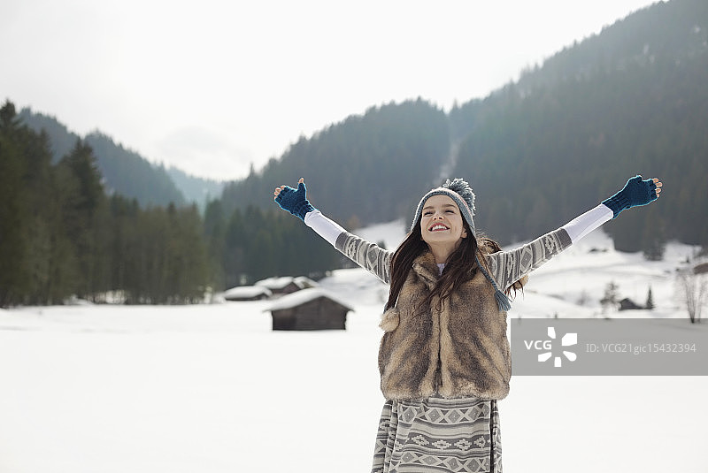 无忧无虑的女人在雪地里张开双臂图片素材