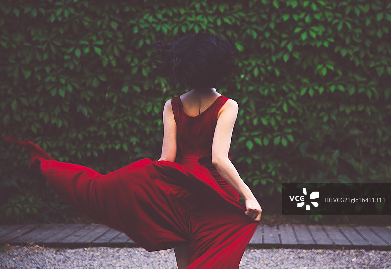一个穿着红色裙子的年轻亚洲女人。图片素材