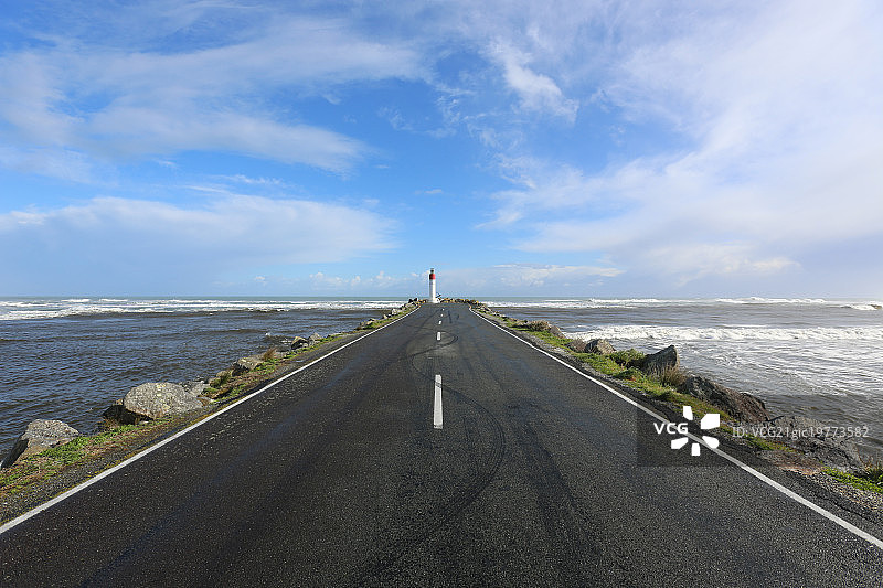 新西兰南岛笔直的公路通向灯塔图片素材