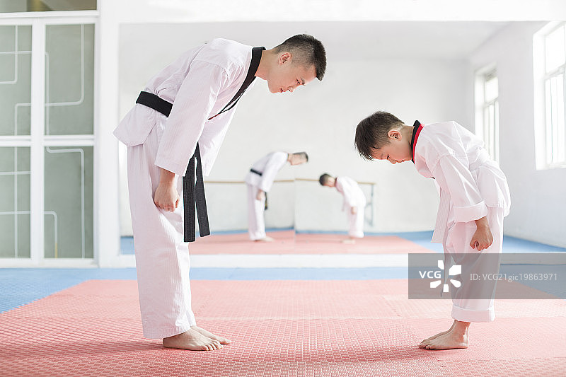 年轻教练教小男孩跆拳道图片素材