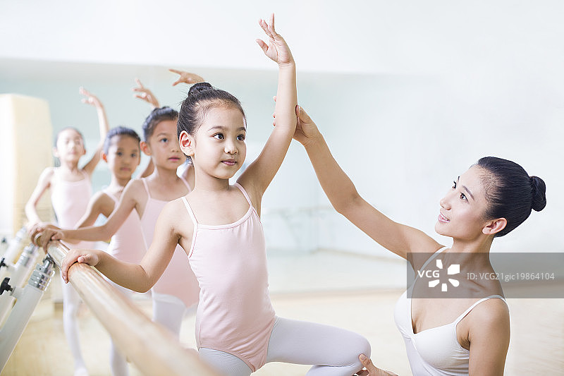 年轻舞蹈老师教小女孩们跳芭蕾图片素材