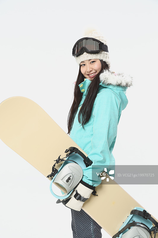 年轻的日本女子穿着滑雪板穿在白色的背景图片素材