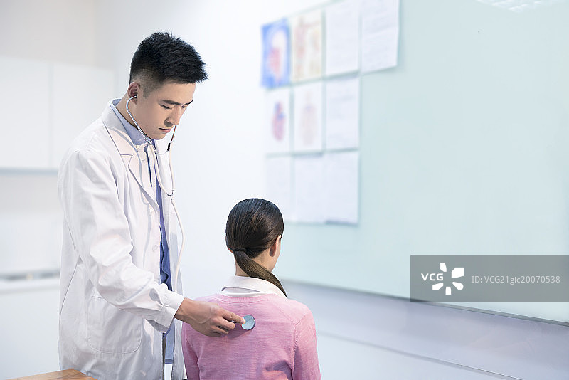 Doctor checking patient with stethoscope图片素材