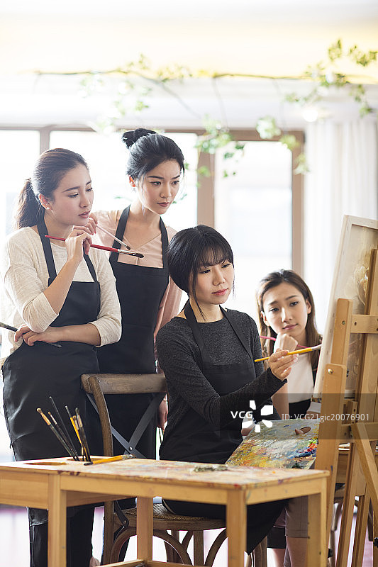 美术老师教年轻女子画画图片素材