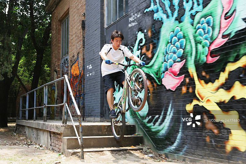 男青年在798艺术区玩自行车图片素材