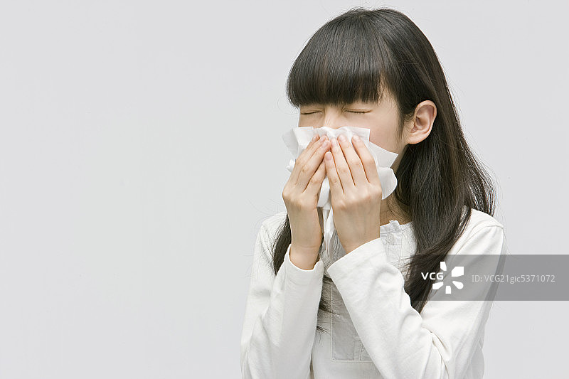 年轻女孩用纸巾擤鼻子图片素材