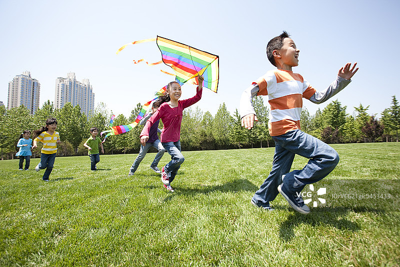 儿童在公园草地上奔跑图片素材