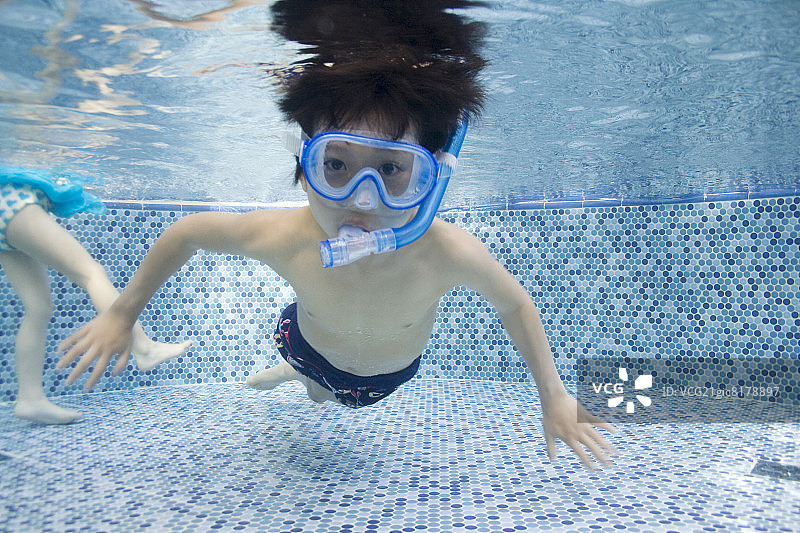 男孩在游泳池里穿着通气管图片素材