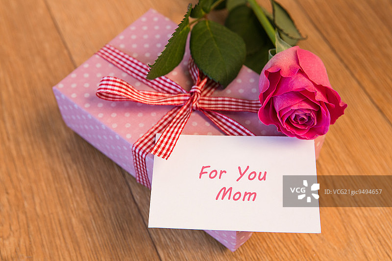 粉红色的礼物与母亲节贺卡和粉红色的玫瑰在木桌上图片素材