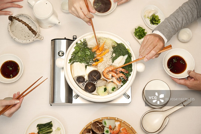 高角度的手服务自己的晚餐在桌子上图片素材