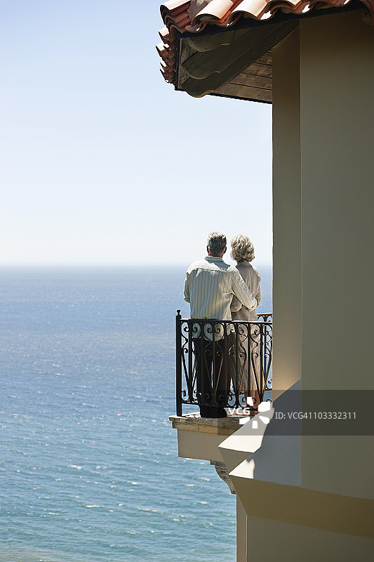 一对老年夫妇在阳台上俯瞰大海图片素材