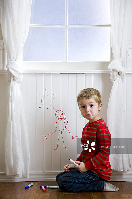 男孩在墙上画画图片素材