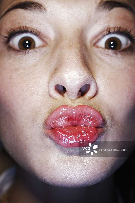 年轻女子抿着嘴唇，特写图片素材