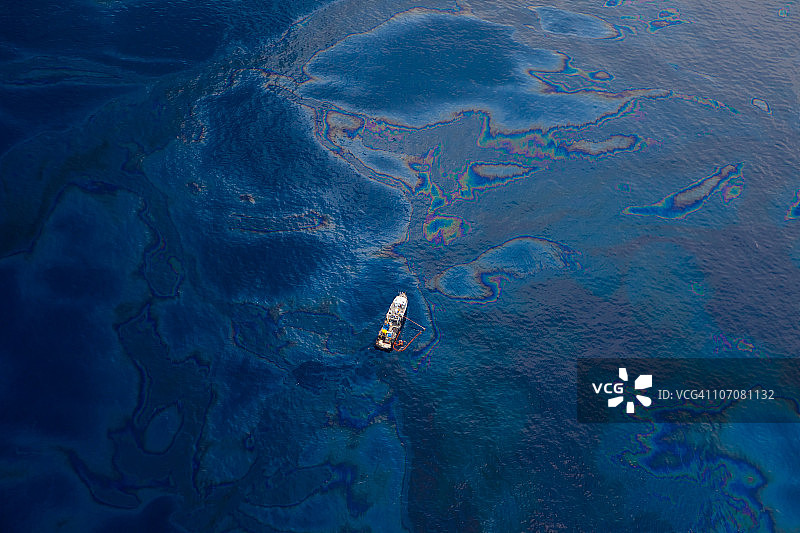 一艘白色的船在墨西哥湾被油覆盖的水面上图片素材