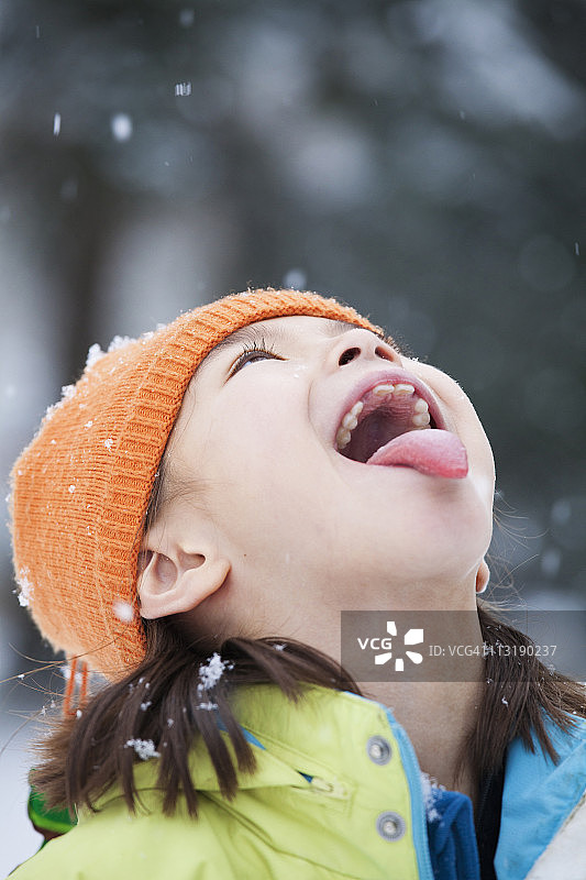 混血女孩用舌头接雪花图片素材
