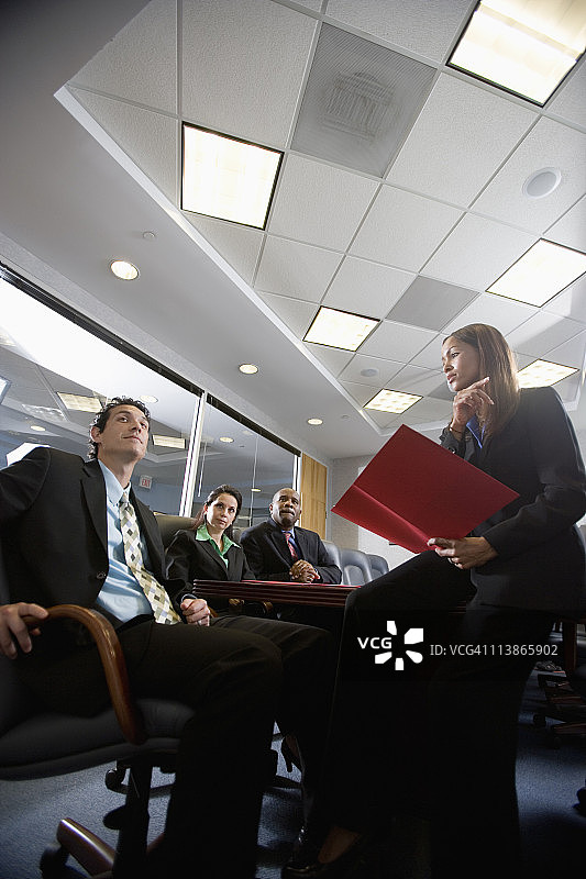 在一个正式的会议室里，商业人士在演讲时的低角度视角图片素材