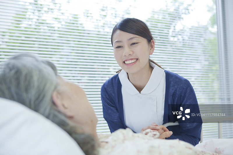 日本本州神奈川县，一名护士牵着一位老年妇女的手图片素材