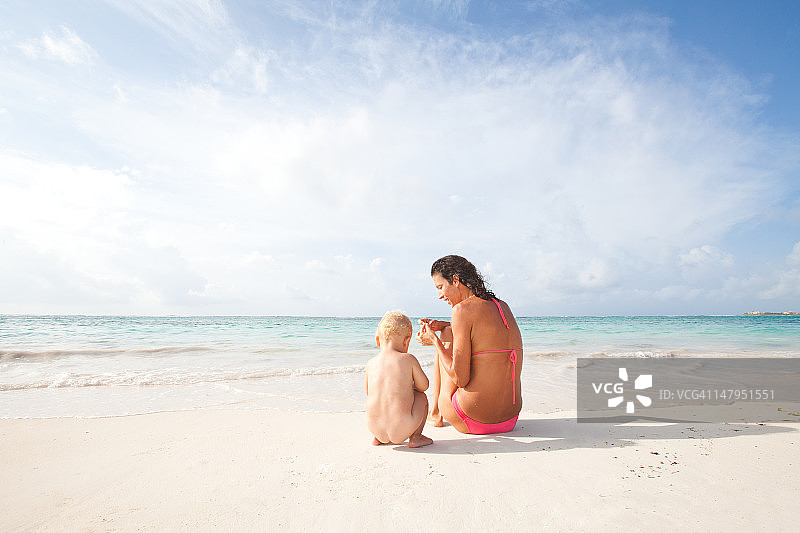妈妈和宝宝在热带海滩上放松图片素材