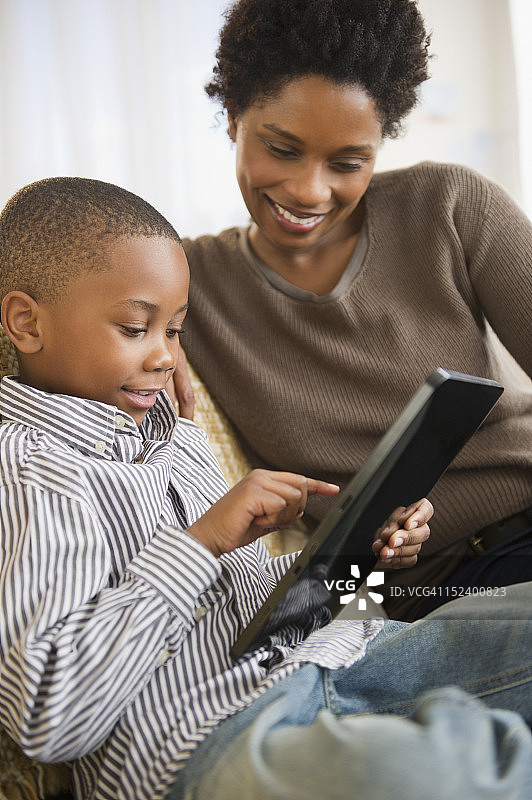 黑人母亲和儿子在用数码平板电脑图片素材