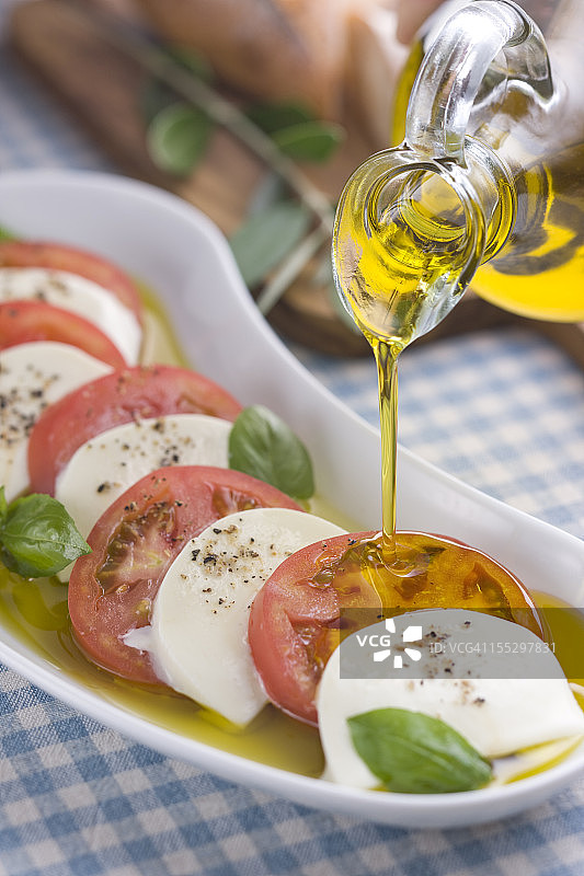 将橄榄油倒在意大利沙拉酱上图片素材