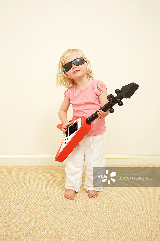 小孩戴着太阳镜，弹吉他图片素材