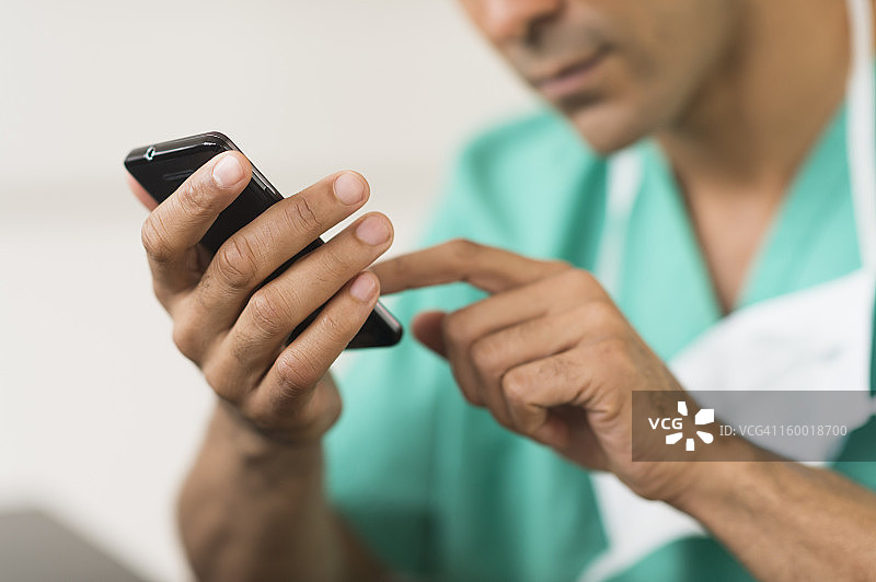男性外科医生在医院使用手机的近距离观察图片素材