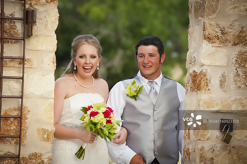 美国德克萨斯州，新娘和新郎手捧新娘花束，面带微笑图片素材